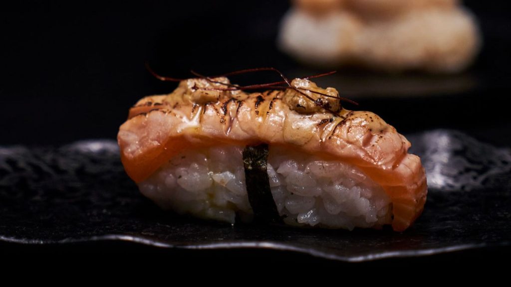 Presentación gourmet de sushi fusión en restaurante de Valencia.